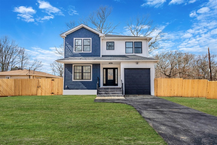 View of front of home with a front yard, fence, roof with shingles, an attached garage, and aphalt driveway