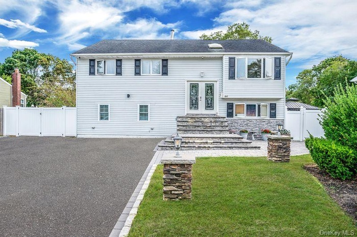 Rear view of house featuring a gate, a fenced backyard, french doors, and stone siding