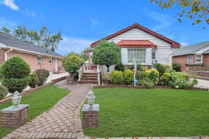 View of front of house featuring brick siding and a front yard