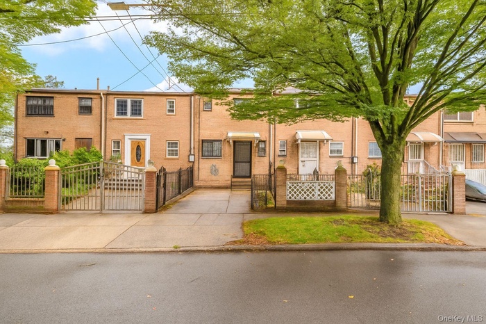 View of front of property with a gate, a fenced front yard, and brick siding