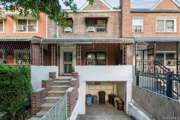 View of front facade featuring brick siding, a porch, and an attached garage