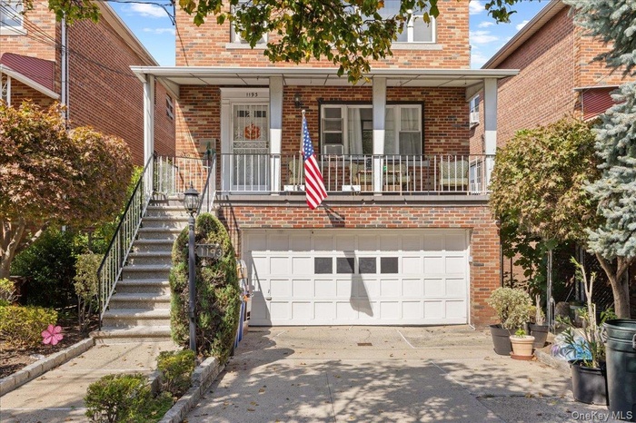 View of front facade with brick siding, a garage, stairway, concrete driveway, and a porch