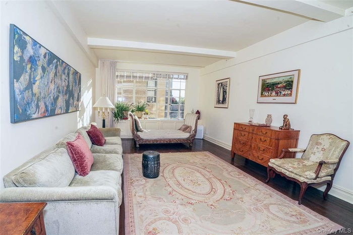 Living room featuring beam ceiling and dark wood finished floors