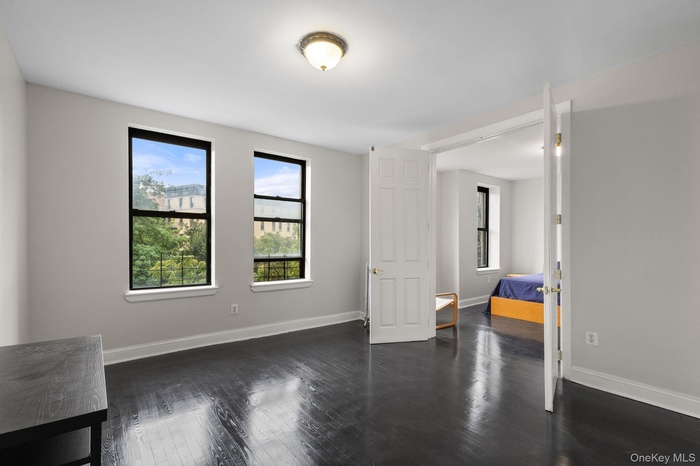 Bedroom featuring dark wood-type flooring and baseboards