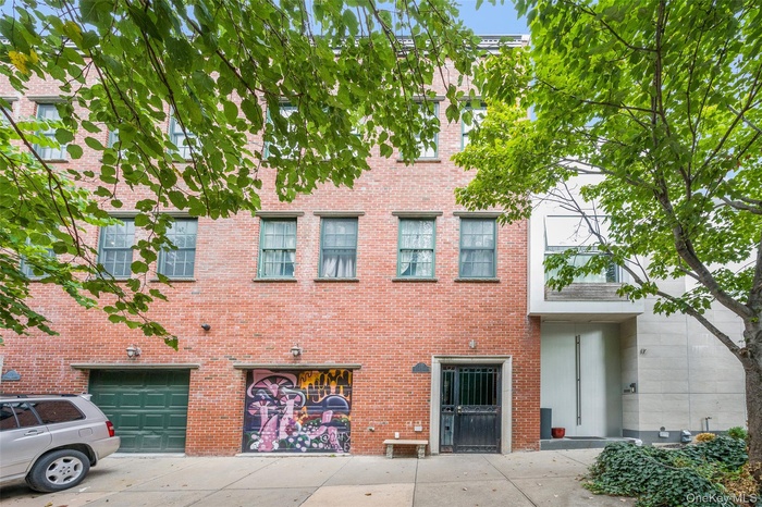 View of front facade featuring brick siding, an attached garage, and driveway