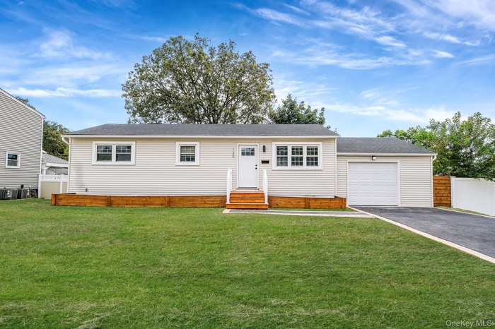 View of front of property with asphalt driveway, a garage, a shingled roof, and entry steps