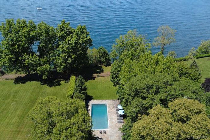 View from above of property with a pool and a nearby body of water
