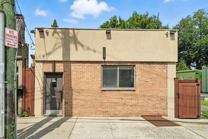 View of front of property with a gate and brick siding