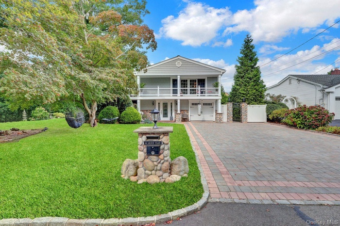 Welcome to this Beautiful Lakeview Property w Tech Pavered driveway, stone siding, a front lawn, covered porch, and french doors