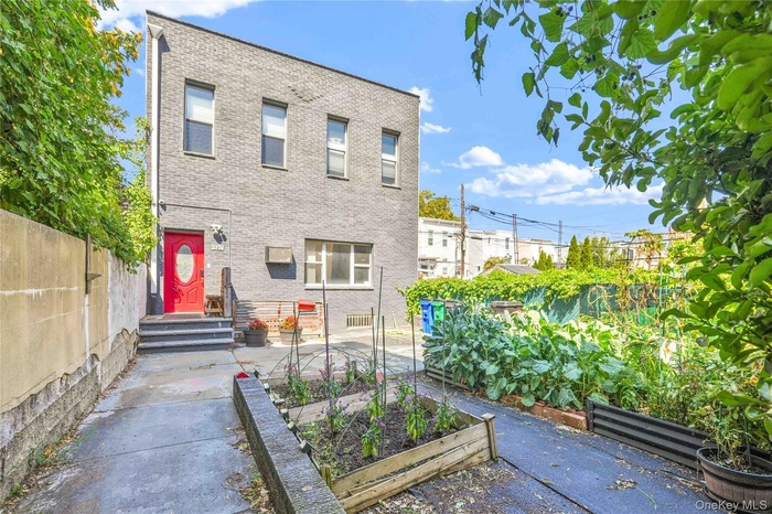 View of front of property featuring a garden and brick siding