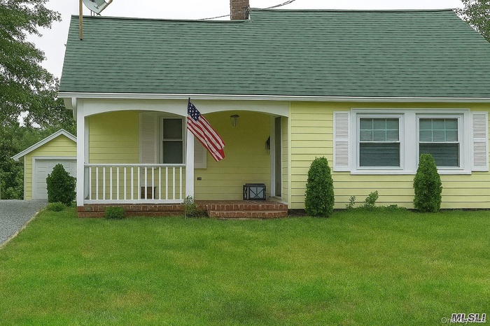 Front of home with porch and entry to living room.