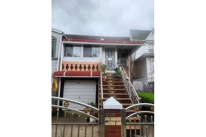 View of property featuring an attached garage and stairs