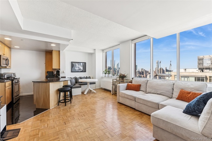 Living area featuring baseboards, a skyline view, recessed lighting, and a textured ceiling