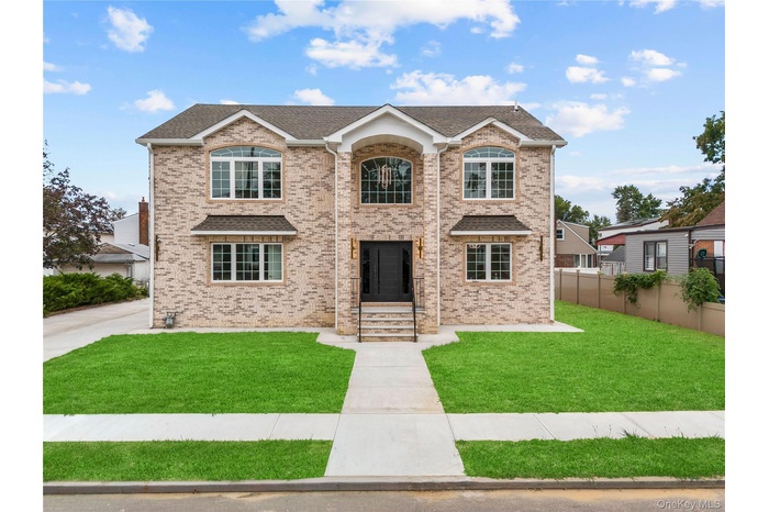 Traditional-style home with brick siding and roof with shingles