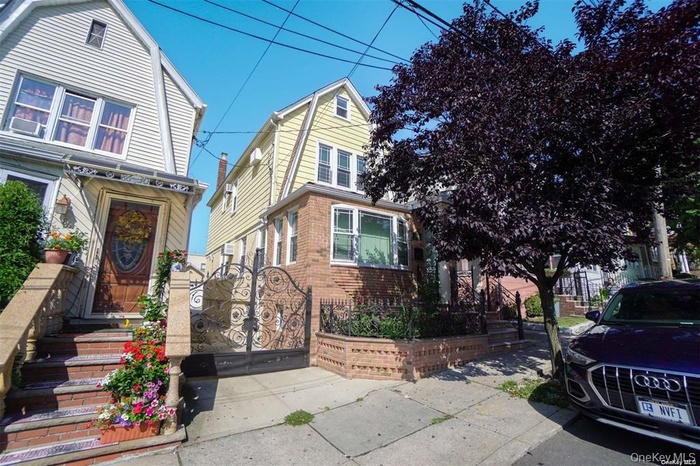 Dutch colonial featuring a gate and brick siding