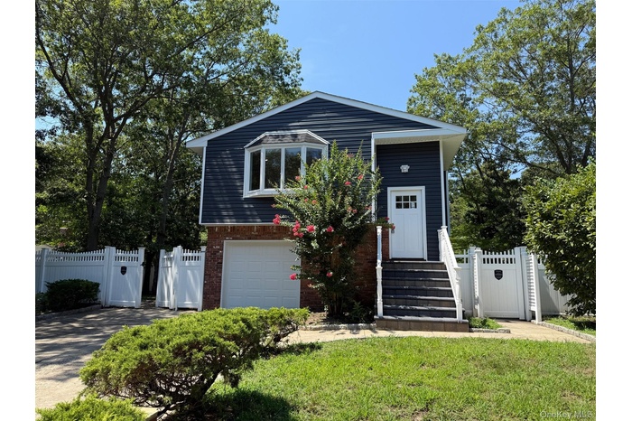 View of front facade with a gate and brick siding