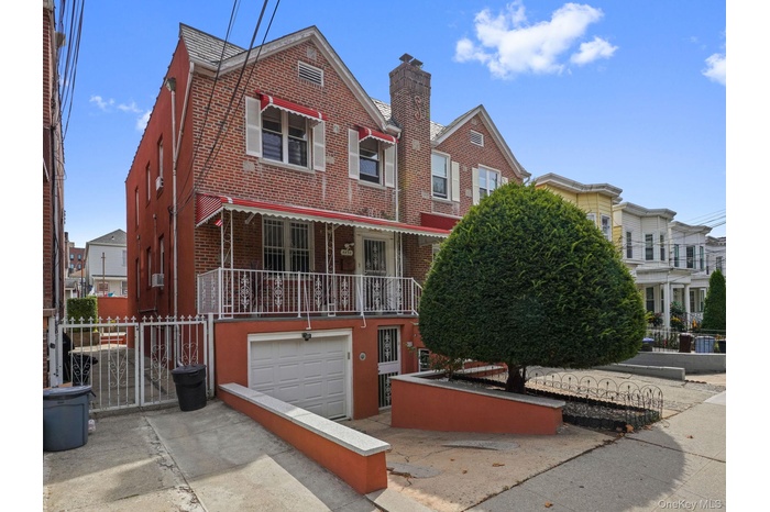Traditional home featuring brick siding, a residential view, a garage, and a chimney