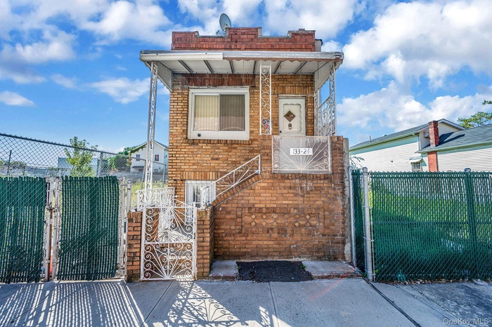 View of front of house with a gate, brick siding, and a fenced front yard
