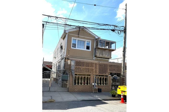 View of front facade featuring a balcony, a gate, and brick siding