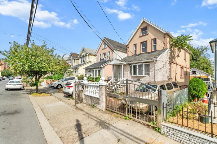 View of front of home with a fenced front yard, stucco siding, and a residential view