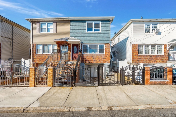 View of front of house featuring a gate, a fenced front yard, and brick siding