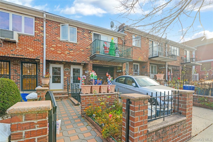 View of front of home featuring a balcony, brick siding, and a patio