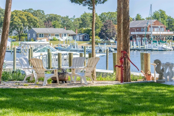 Dock with a water view, a lawn, and view of scattered trees