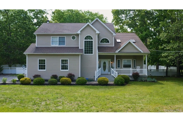 View of front facade with covered porch and roof with shingles