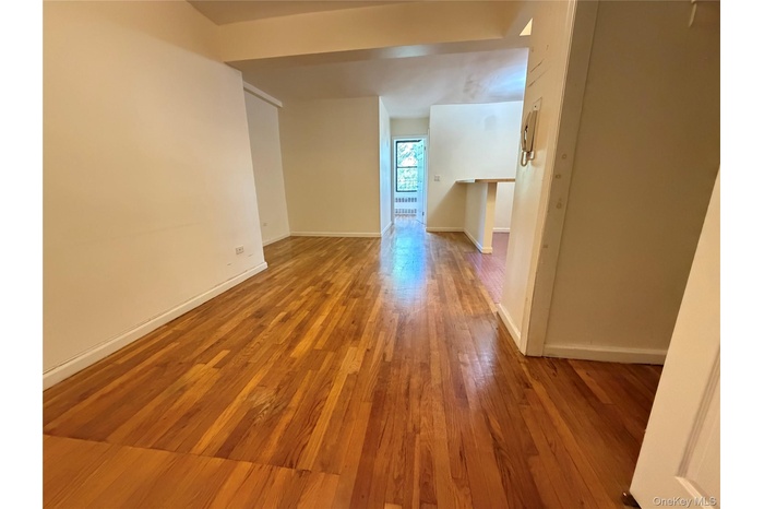 Spare room featuring light wood-type flooring and baseboards