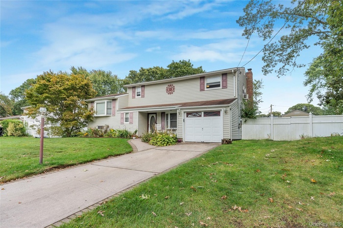 View of front of house featuring an attached garage, a chimney, and concrete driveway