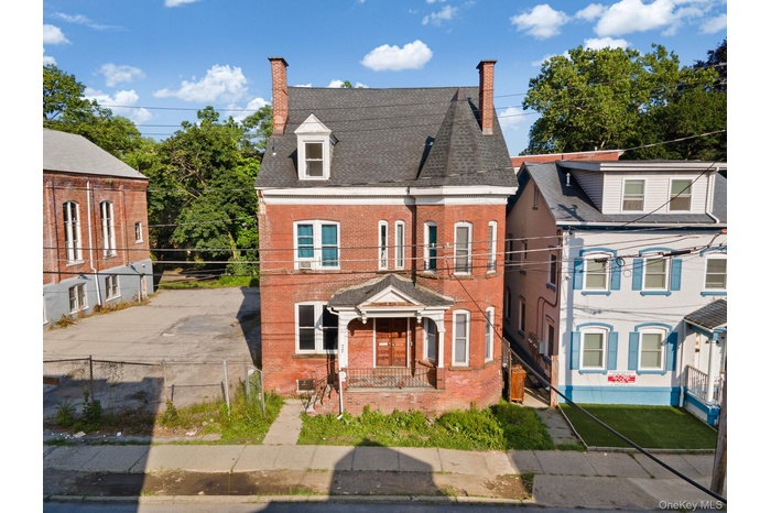 View of front of home featuring brick siding and a chimney