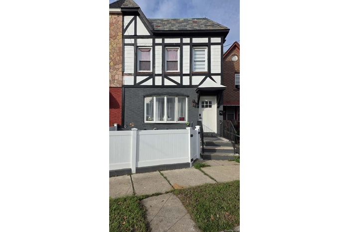 View of front of house with brick siding and a fenced front yard
