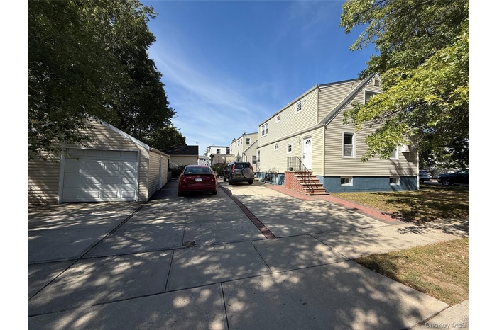 View of side of home with an outdoor structure and a garage