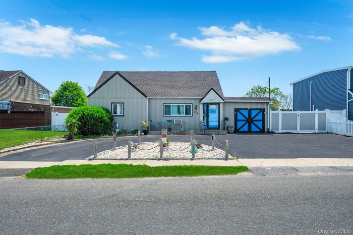 View of front of home featuring driveway and roof with shingles