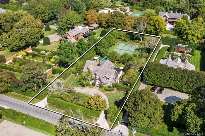 Aerial view of property and surrounding area featuring property parcel outlined and nearby suburban area