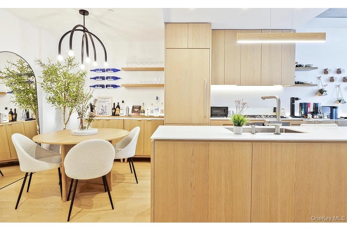 Kitchen featuring open shelves, light brown cabinetry, modern cabinets, and light wood-style floors