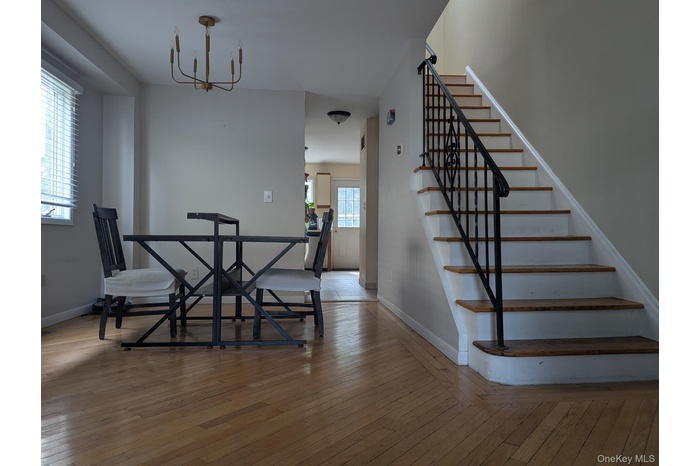 Dining room featuring stairs, light wood-type flooring, and a chandelier