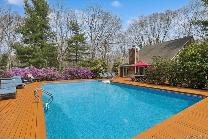Outdoor pool featuring a wooden deck and outdoor dining area