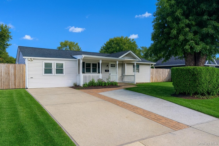 Ranch-style home with a porch and roof with shingles