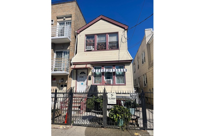 View of front of home featuring a fenced front yard and a gate