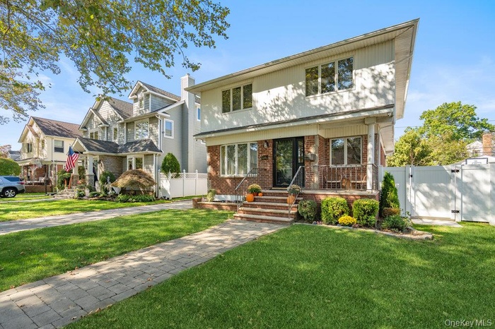 View of front of home featuring a gate and brick siding