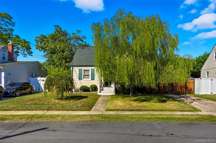 View of property hidden behind natural elements with roof with shingles