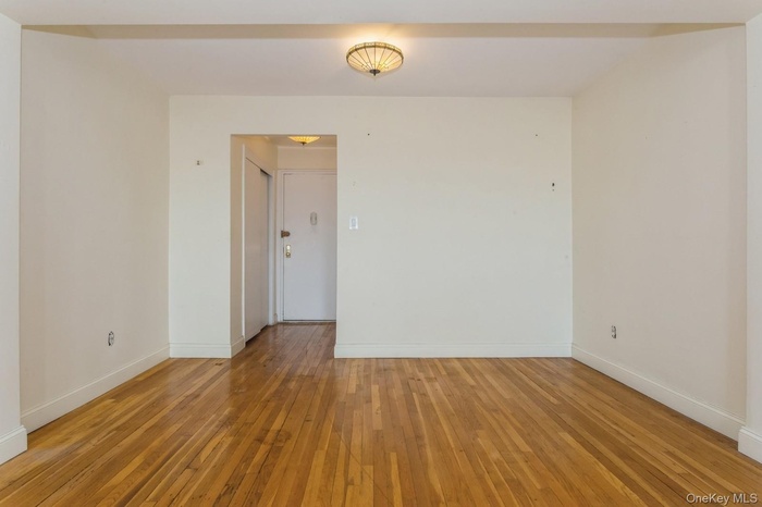 Spare room featuring light wood finished floors and baseboards