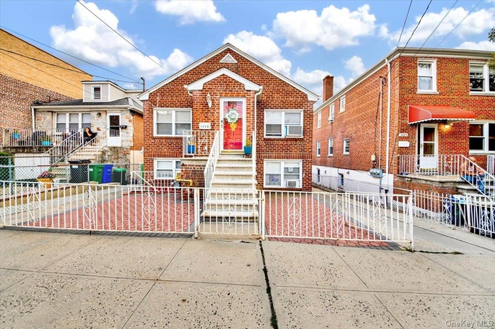View of front of property featuring a gate, a fenced front yard, and brick siding