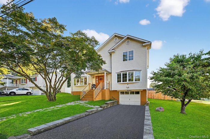 View of front facade with driveway and an attached garage