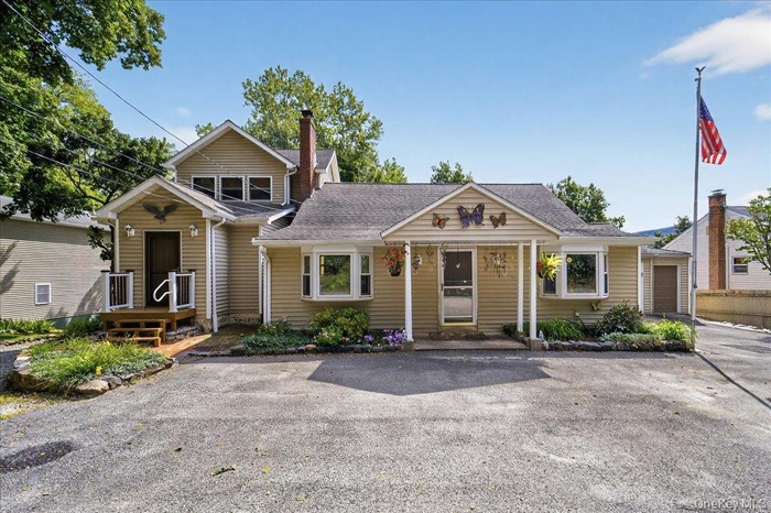 View of front of property featuring a chimney and roof with shingles