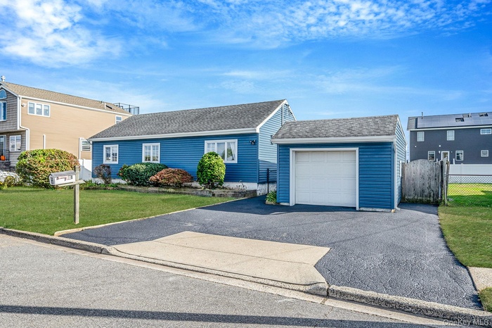 Single story home featuring roof with shingles, driveway, and a garage