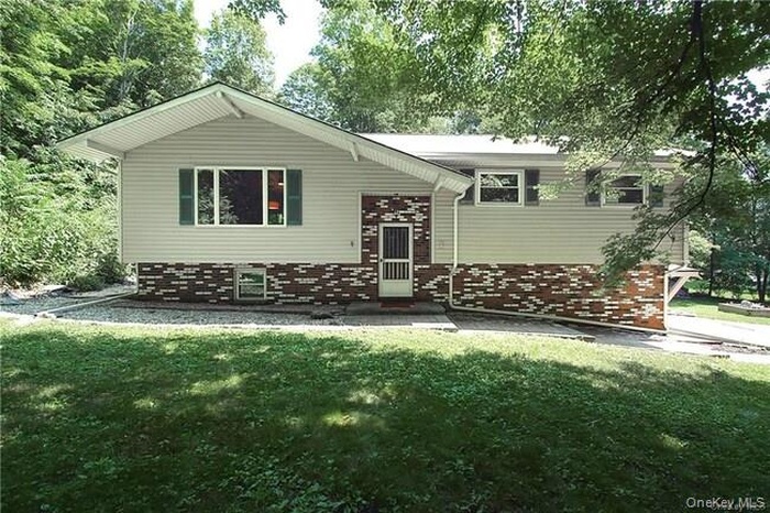 View of front of property featuring brick siding and a front yard