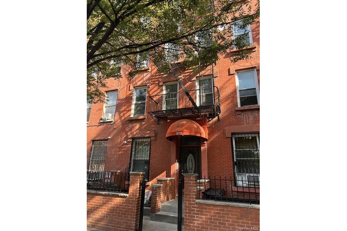 View of front of property featuring brick siding and a fenced front yard