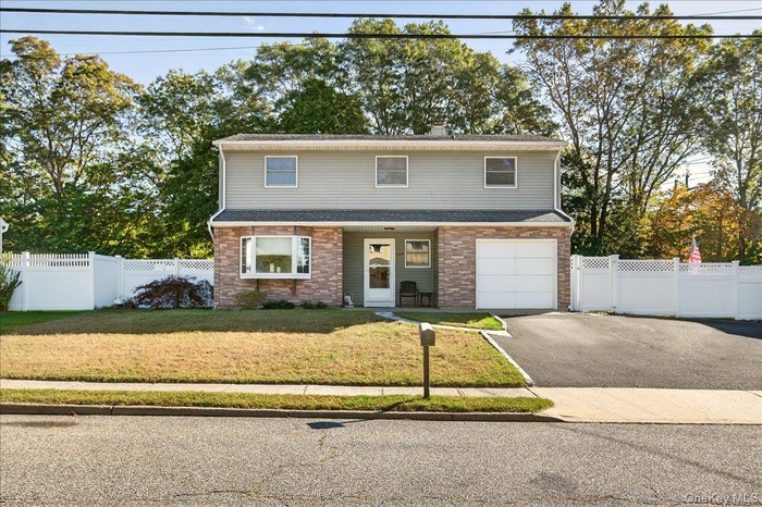 Traditional-style home with asphalt driveway, and covered porch